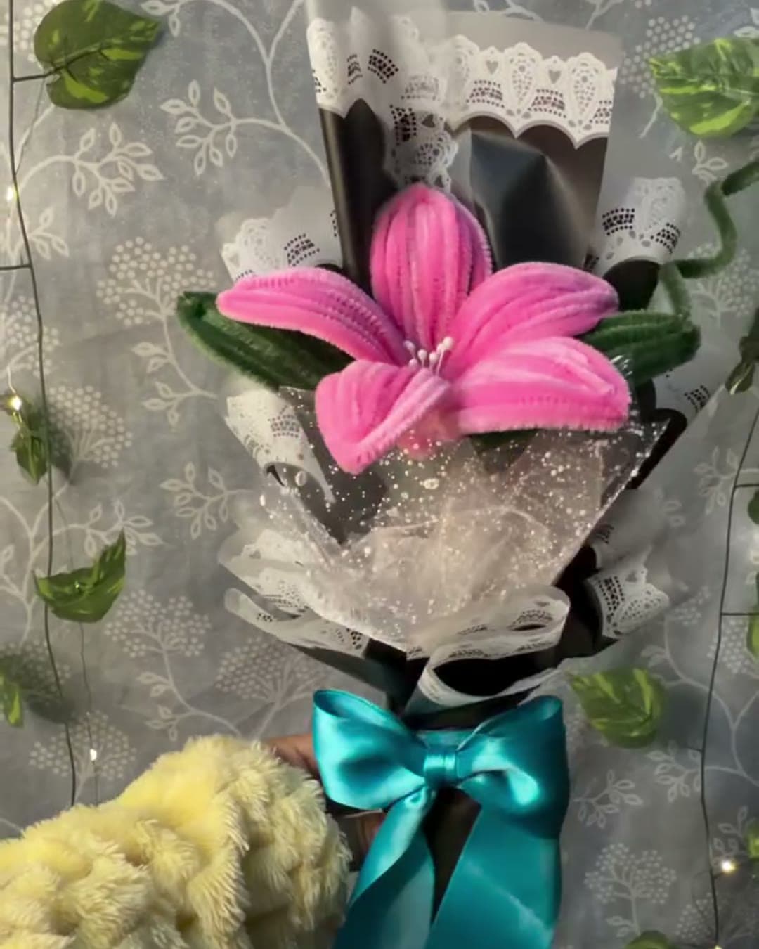 Single pink lily bouquet in black lace wrap with teal bow